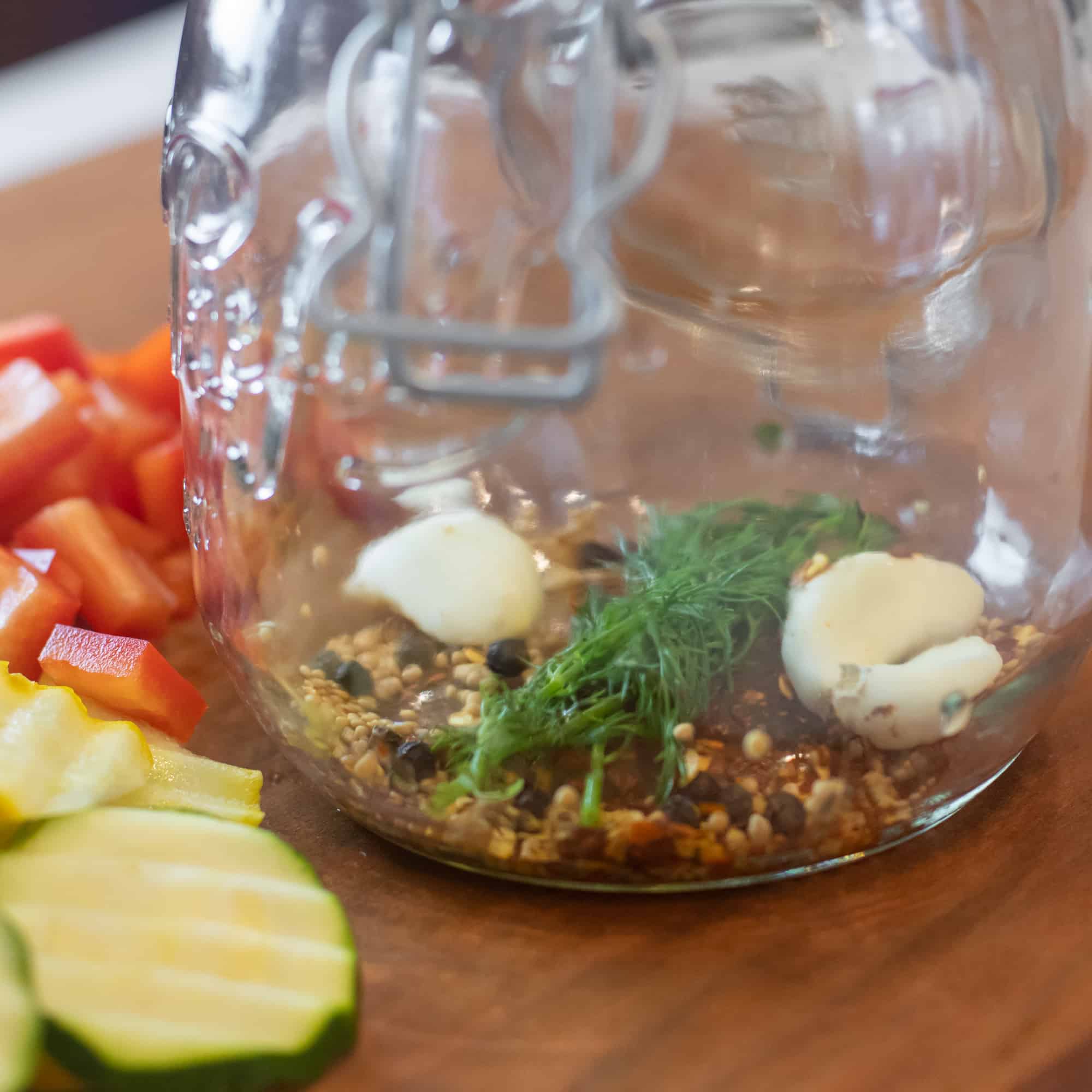 Add fresh dill, garlic cloves, mustard seeds, peppercorns and dried chilies to the jar.