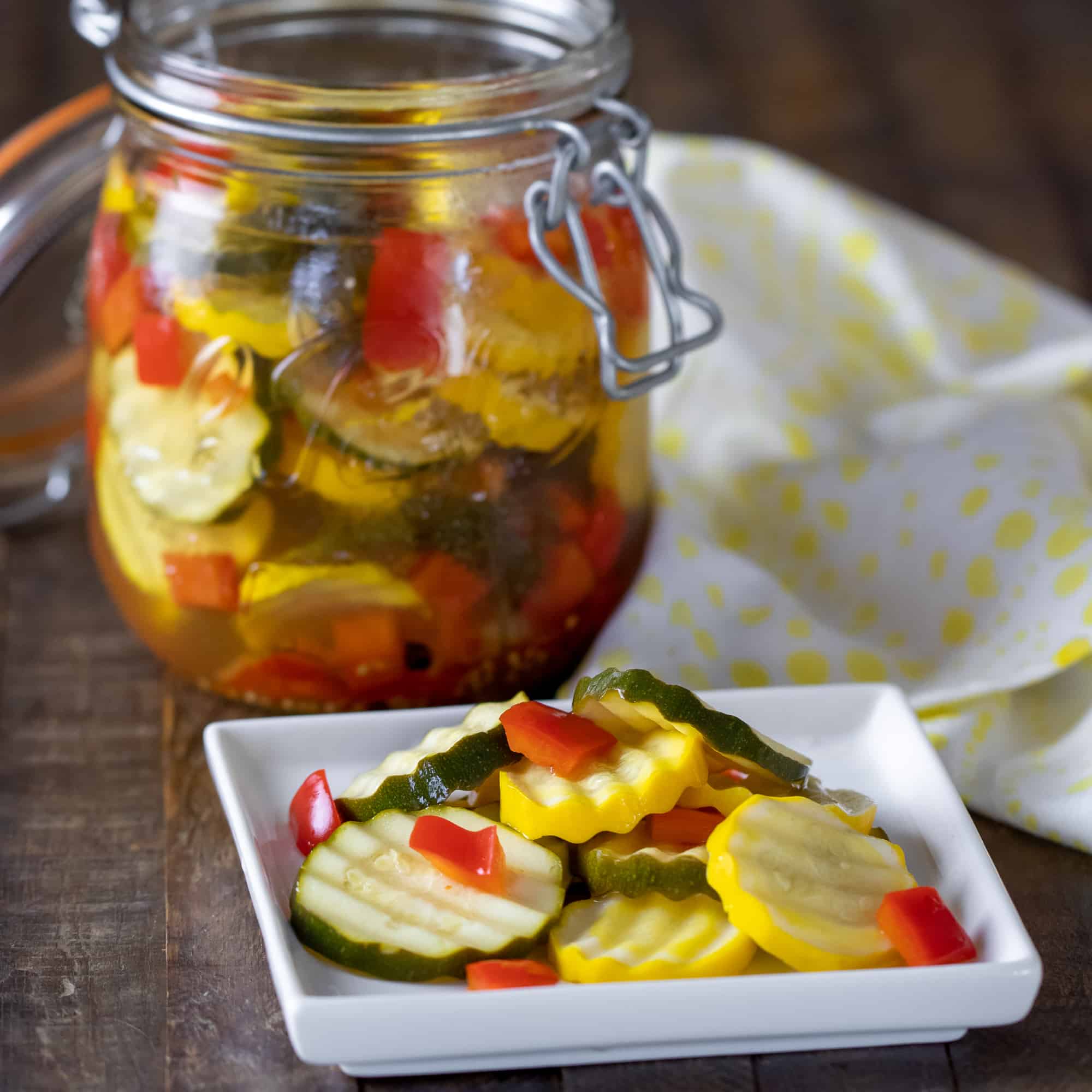 Quick recipe for small batch refrigerator zucchini pickles. Made with both green and yellow zucchini squash, red peppers, garlic, dill, and mustard seeds. 