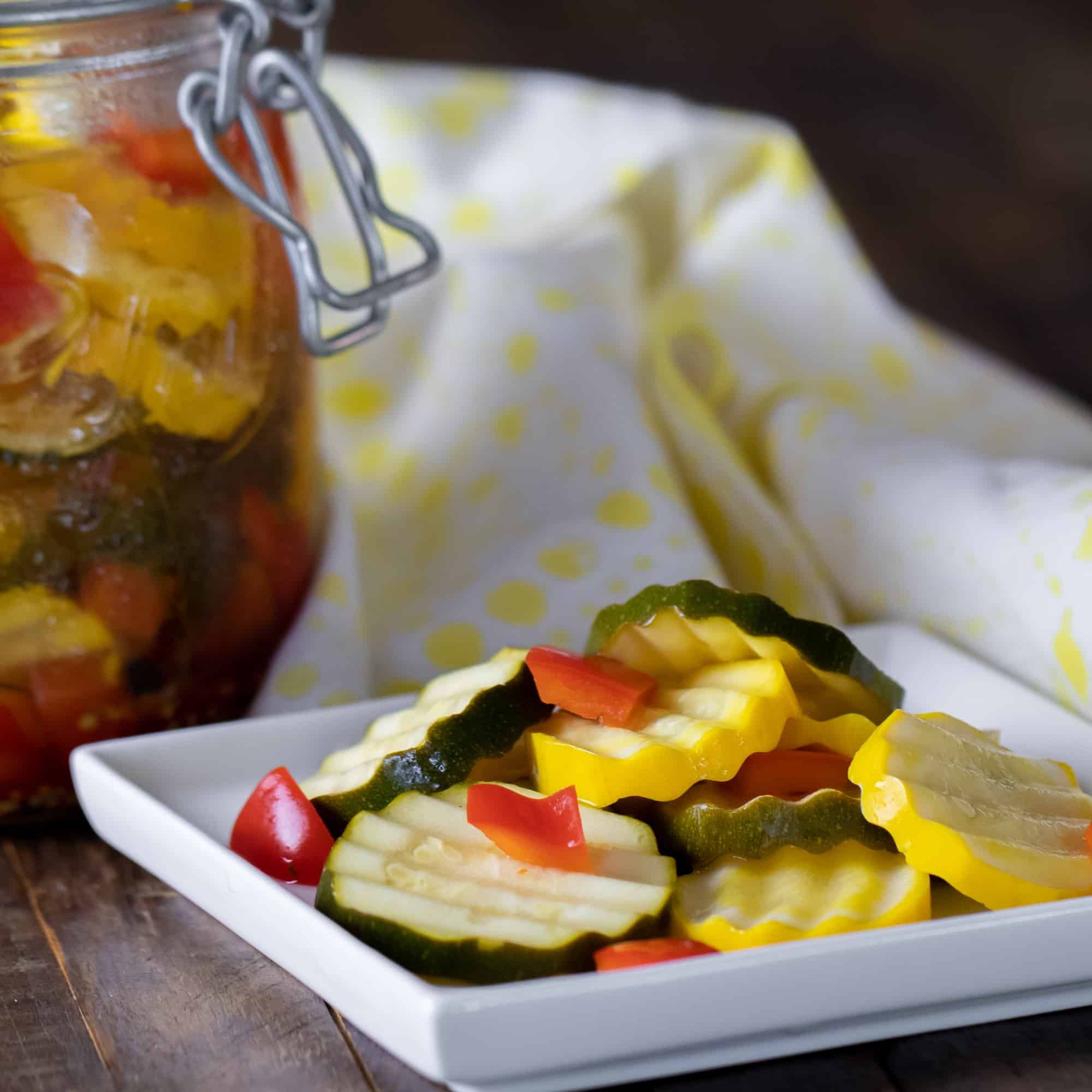 Quick recipe for small batch refrigerator zucchini pickles. Made with both green and yellow zucchini squash, red peppers, garlic, dill, and mustard seeds.