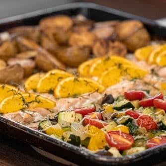 Easy recipe to make a one pan meal with frozen salmon fillets, mini potatoes and mixed vegetables. Delicious weeknight sheet pan dinner!