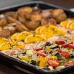 Easy recipe to make a one pan meal with frozen salmon fillets, mini potatoes and mixed vegetables. Delicious weeknight sheet pan dinner!