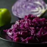 Square image of a plate of the red cabbage and apples.