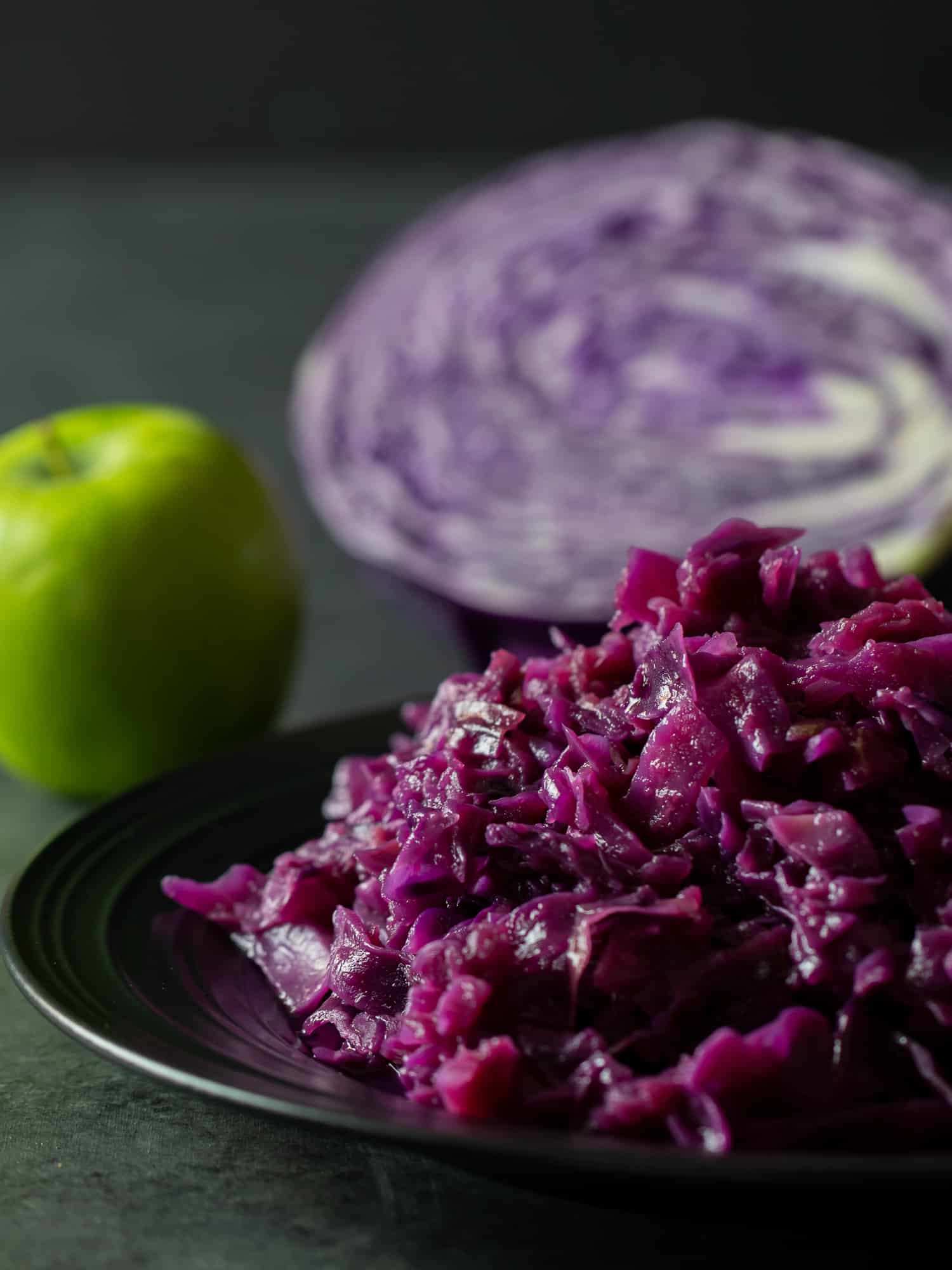 Tall image of a plate of braised red cabbage and apples.