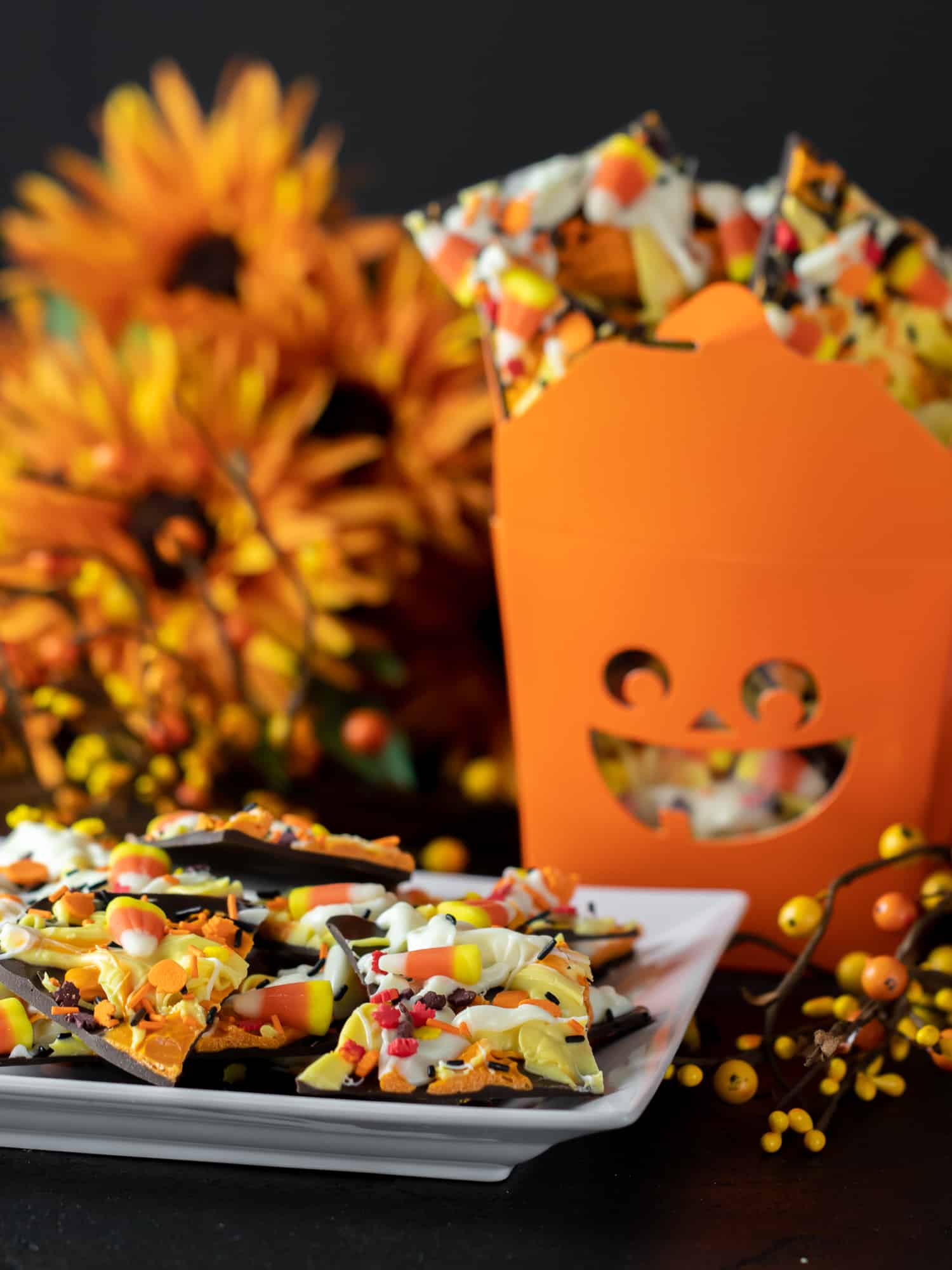 Plate of candy bark and a jack o lantern gift box filled with chocolate bark