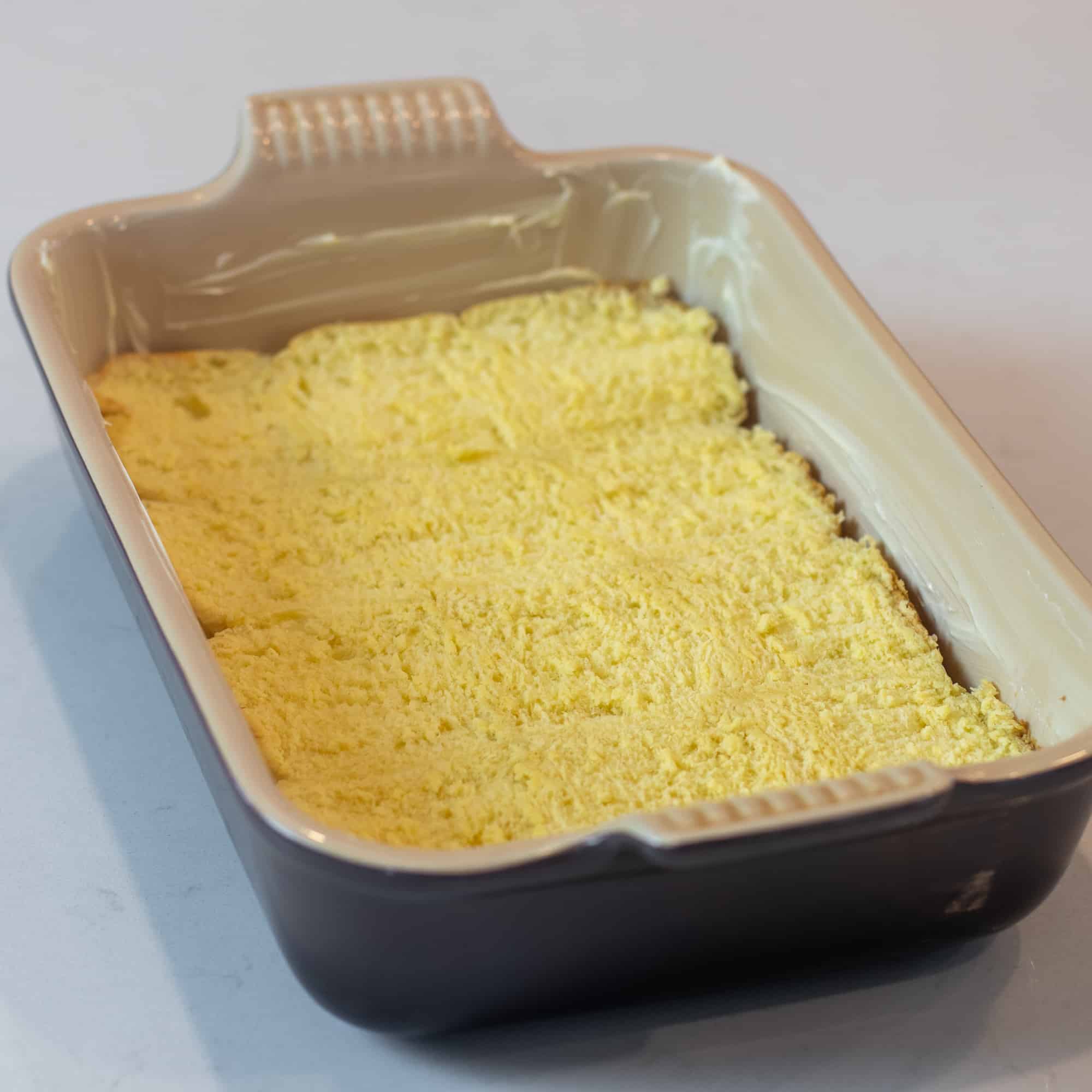 Place the bottom slices of dinner rolls in a baking dish.