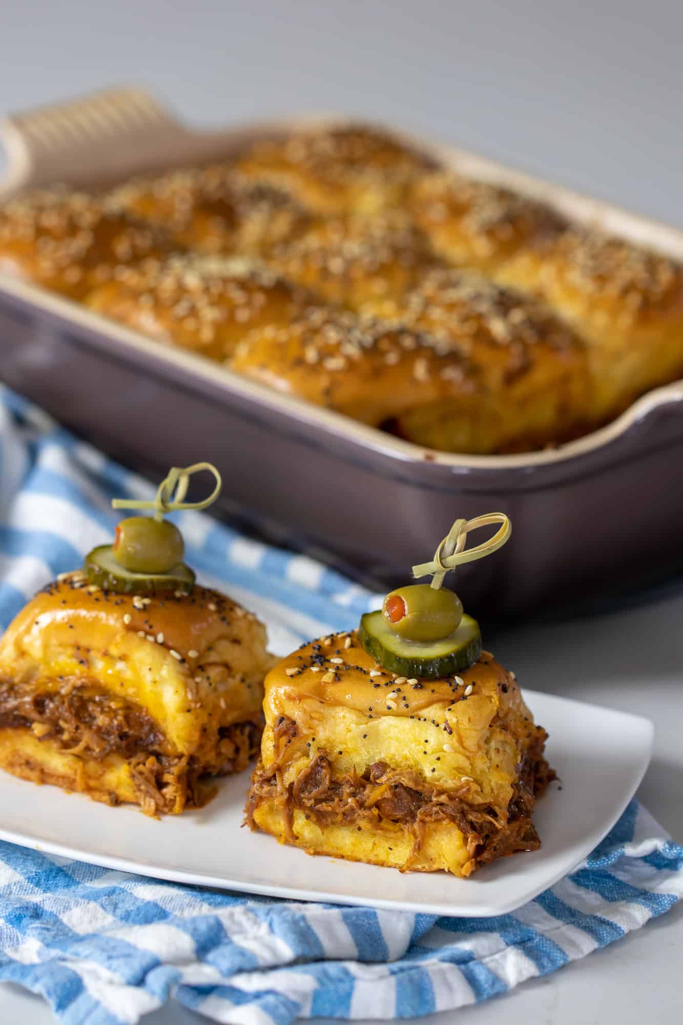 Easy recipe for how to make pulled pork sliders on hawaiian rolls. Make the pulled pork in a crock pot or BBQ smoker. Bake in the oven with cheese.