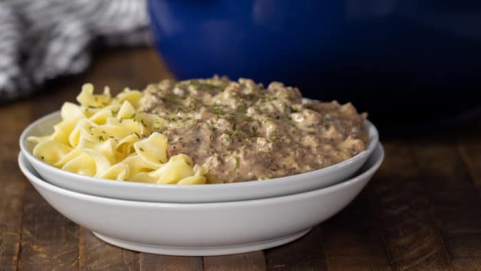 A bowl of creamy beef stroganoff on a bed of egg noodles.