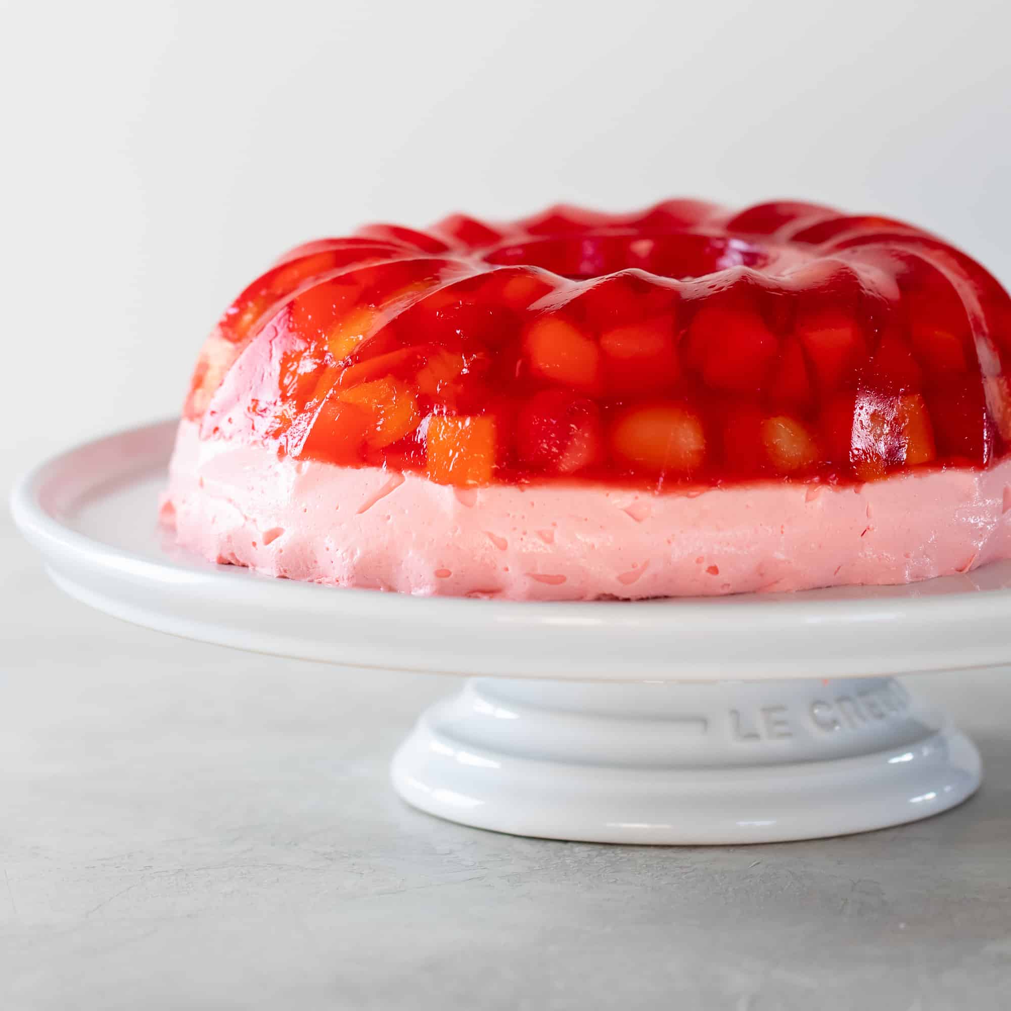 A close of of a jello mold ring on a cake stand.