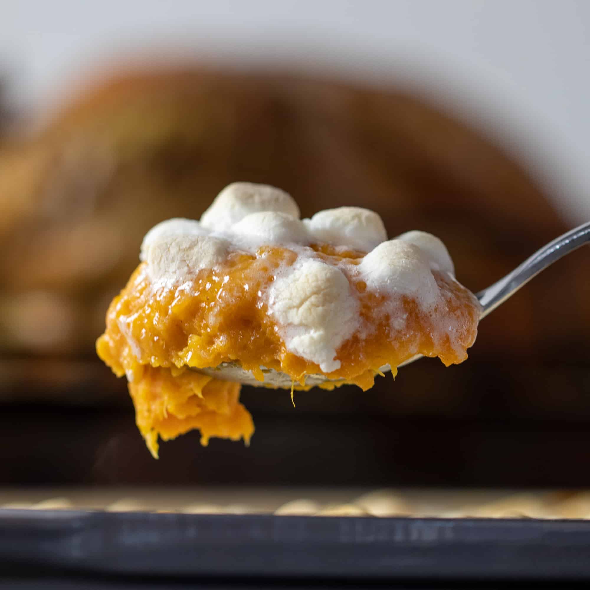 Scoop a spoonful of baked sweet potato casserole.