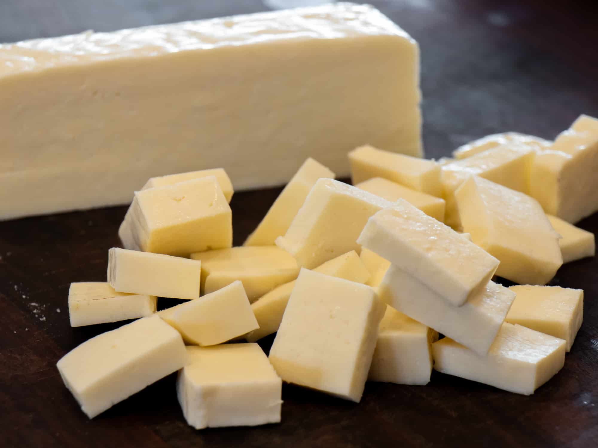 A one pound brick of paneer cheese cut into chunks for Indian matar paneer.