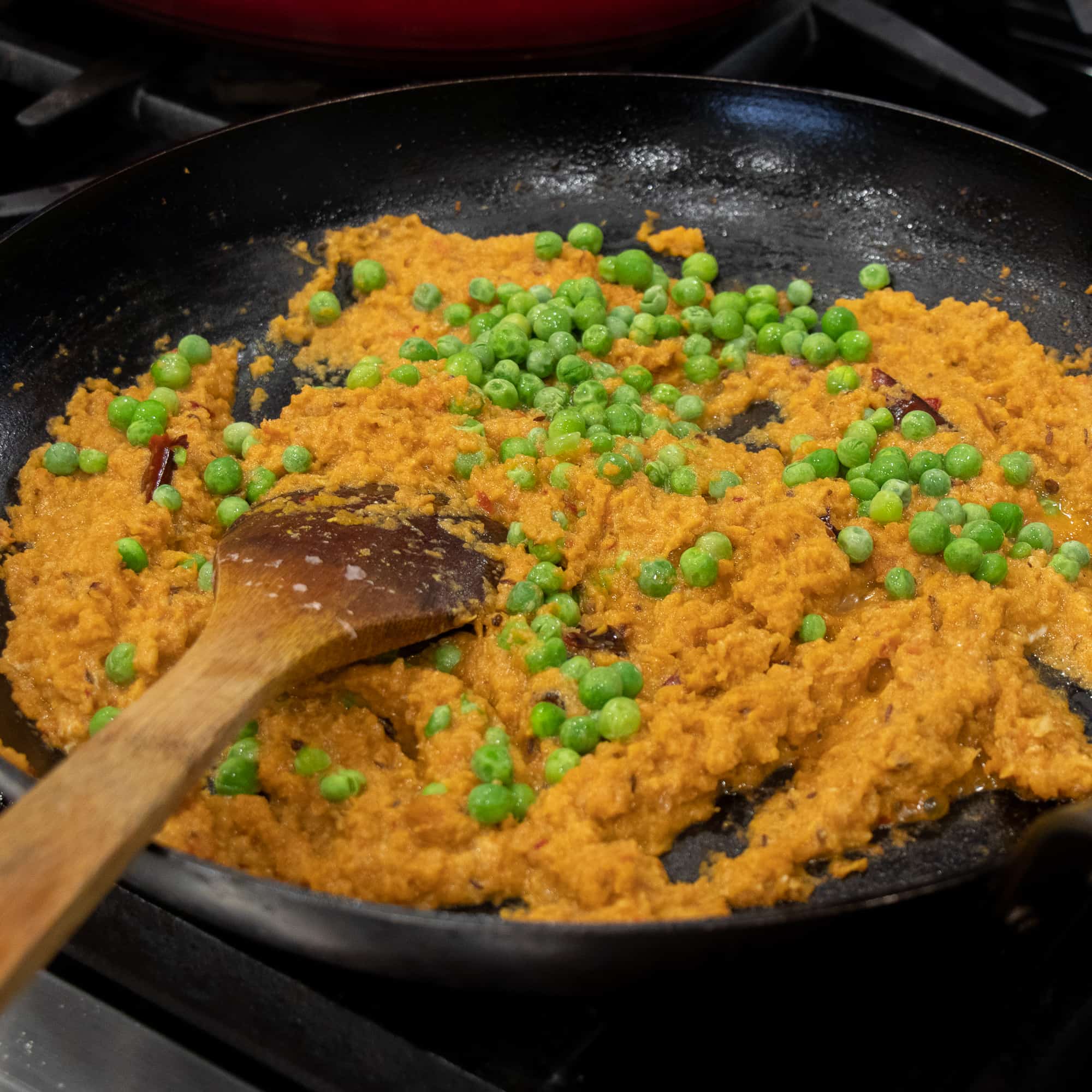 Add the frozen peas to the cooked onions and spices
