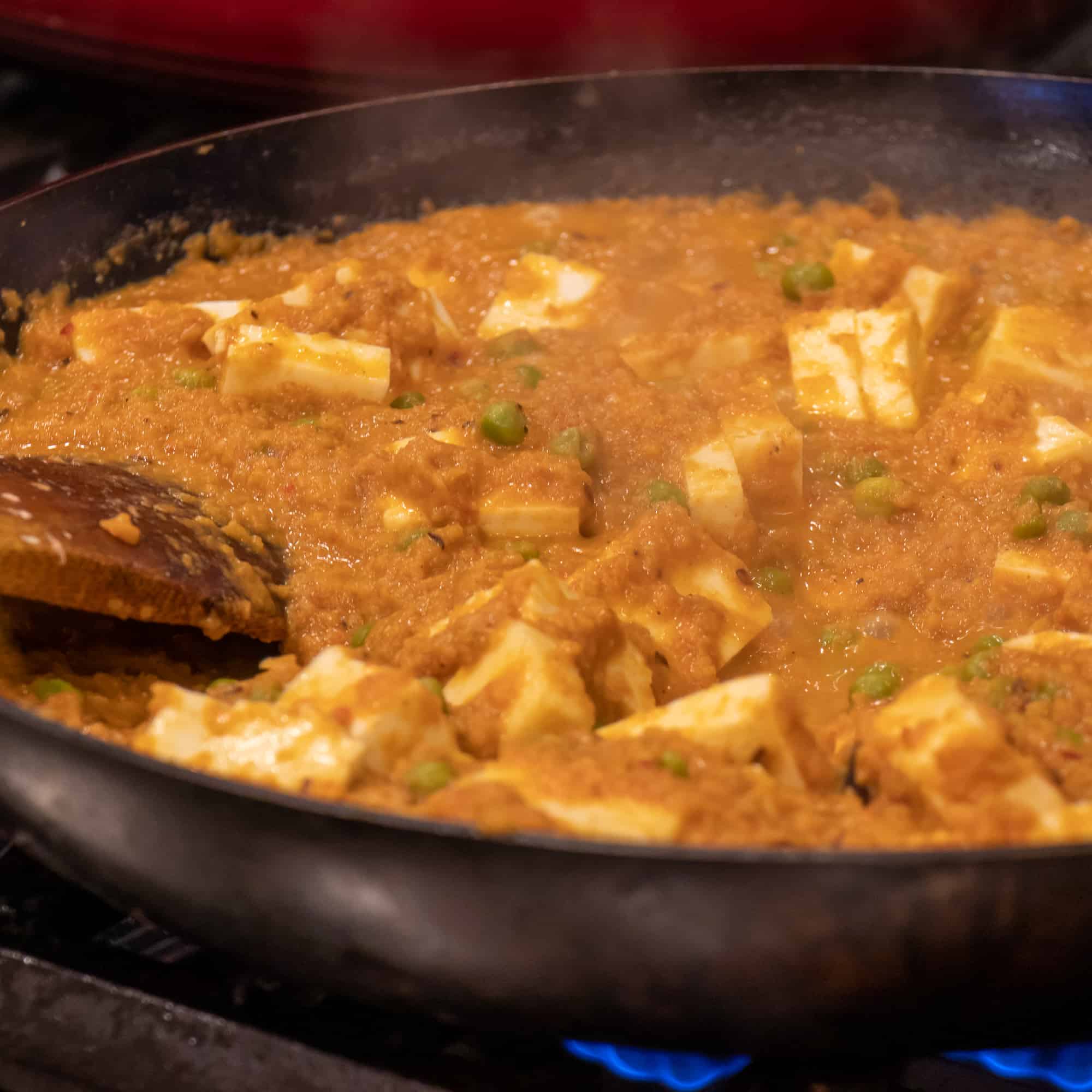 Stir in some more water, curd and cubed paneer cheese.