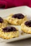 Classic recipe for thumbprint cookies rolled in chopped walnuts with a dollop of raspberry jam on top. Easy recipe and perfect for Christmas holiday baking.