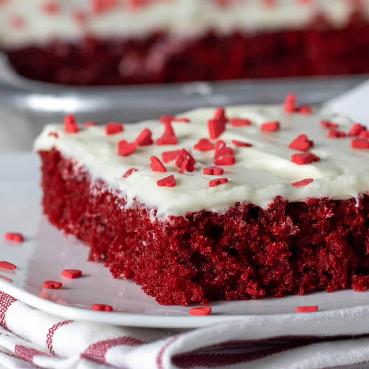 A close up picture of a slice of cake with cream cheese frosting.