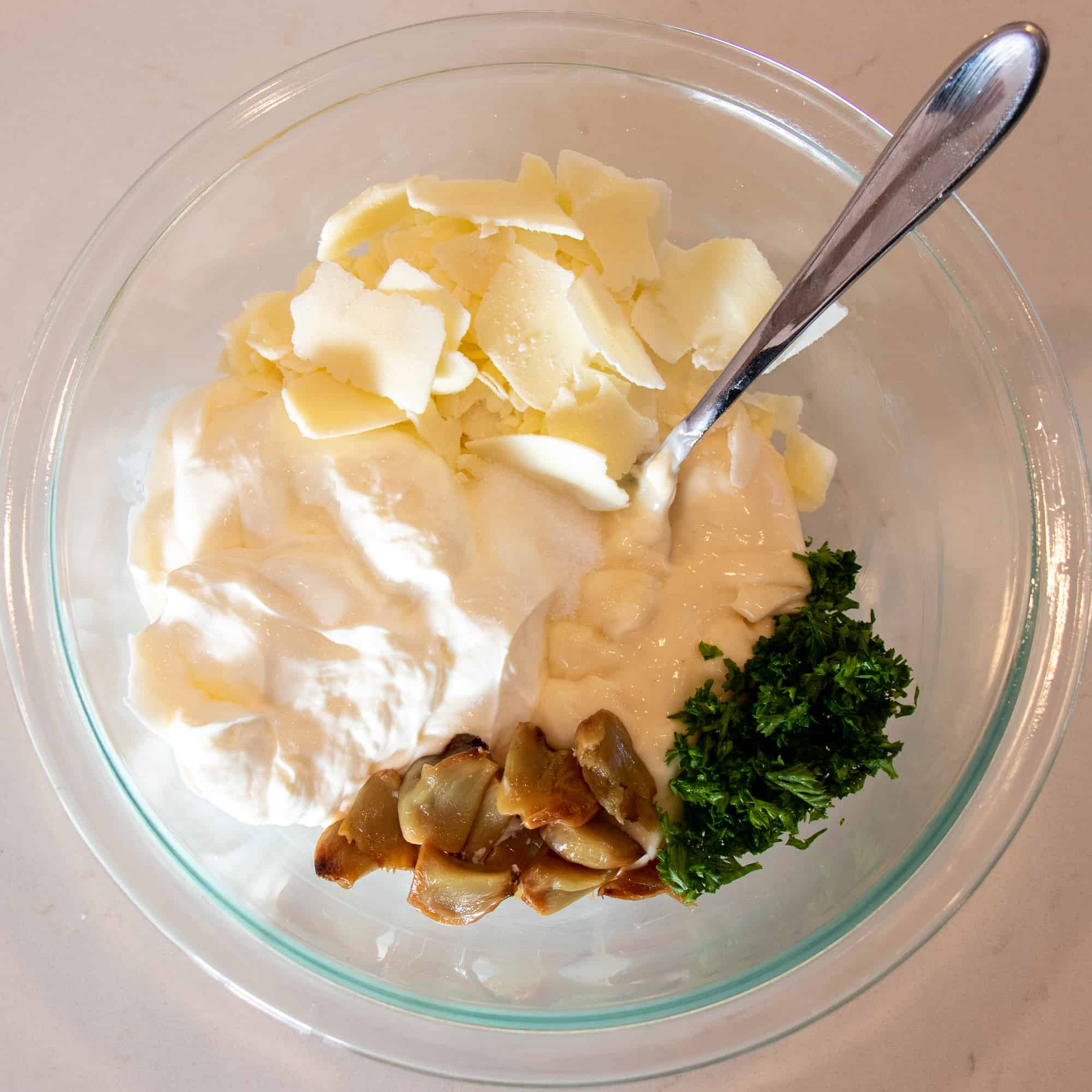 Ingredients for the dip include mayonnaise, sour cream, asiago cheese, roasted garlic and parsley.