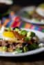 A plate with a Mexican corn tortilla, chorizo, pinto beans and eggs.