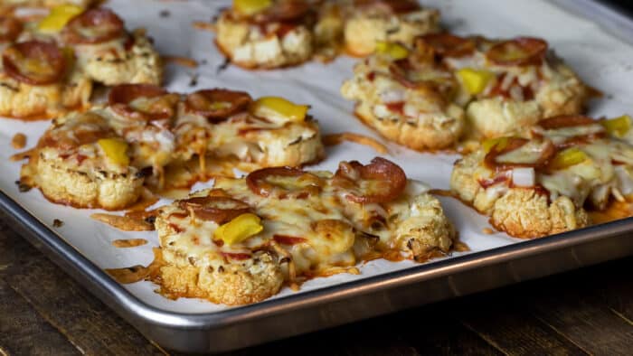 Cauliflower steaks topped with pizza sauce, pepperoni and cheese.