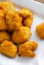 An overhead picture of a plate of nuggets with dipping sauce.