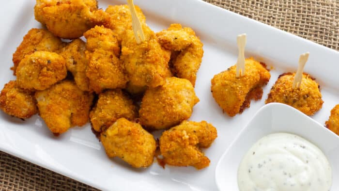 An overhead picture of a plate of nuggets with dipping sauce.