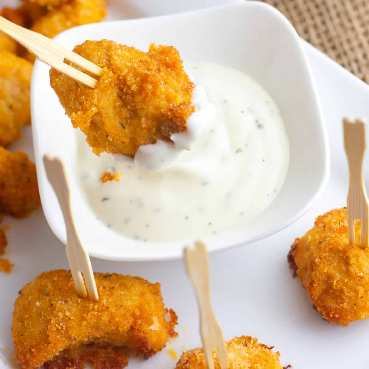 A nugget being dipped in ranch dressing.