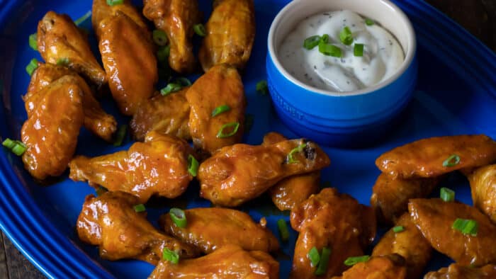 A platter of wings and ranch sauce for dipping.