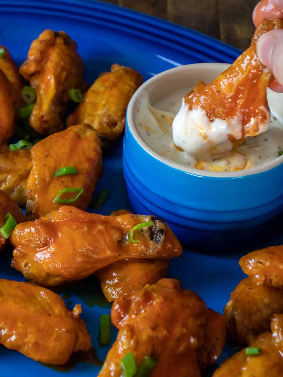 Dipping a wing in ranch dressing.