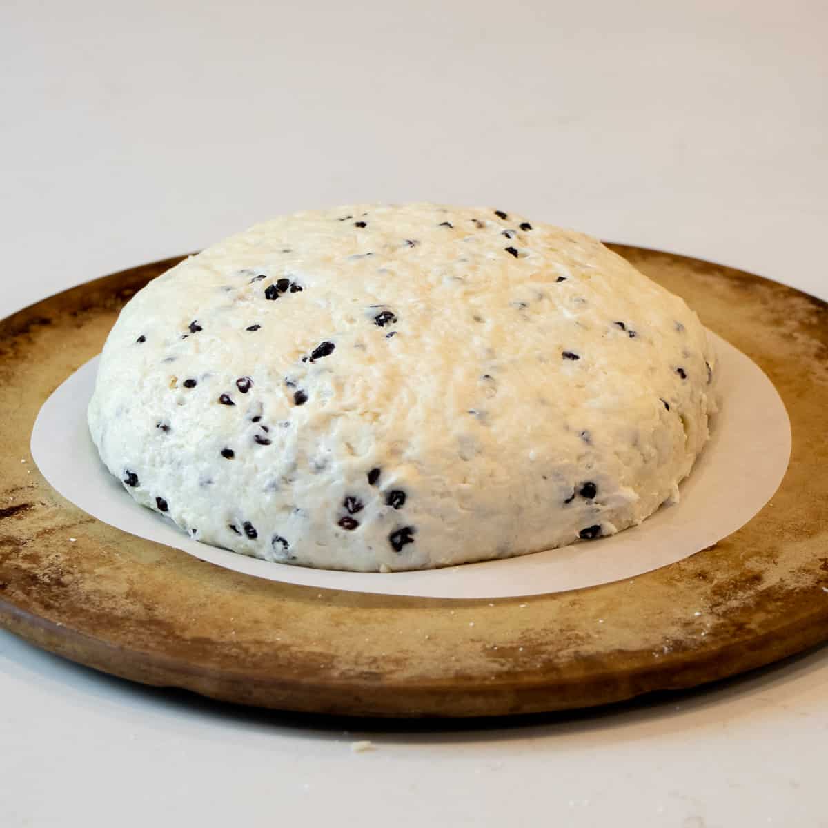 Bread dough formed into a loaf and placed on a pizza stone.