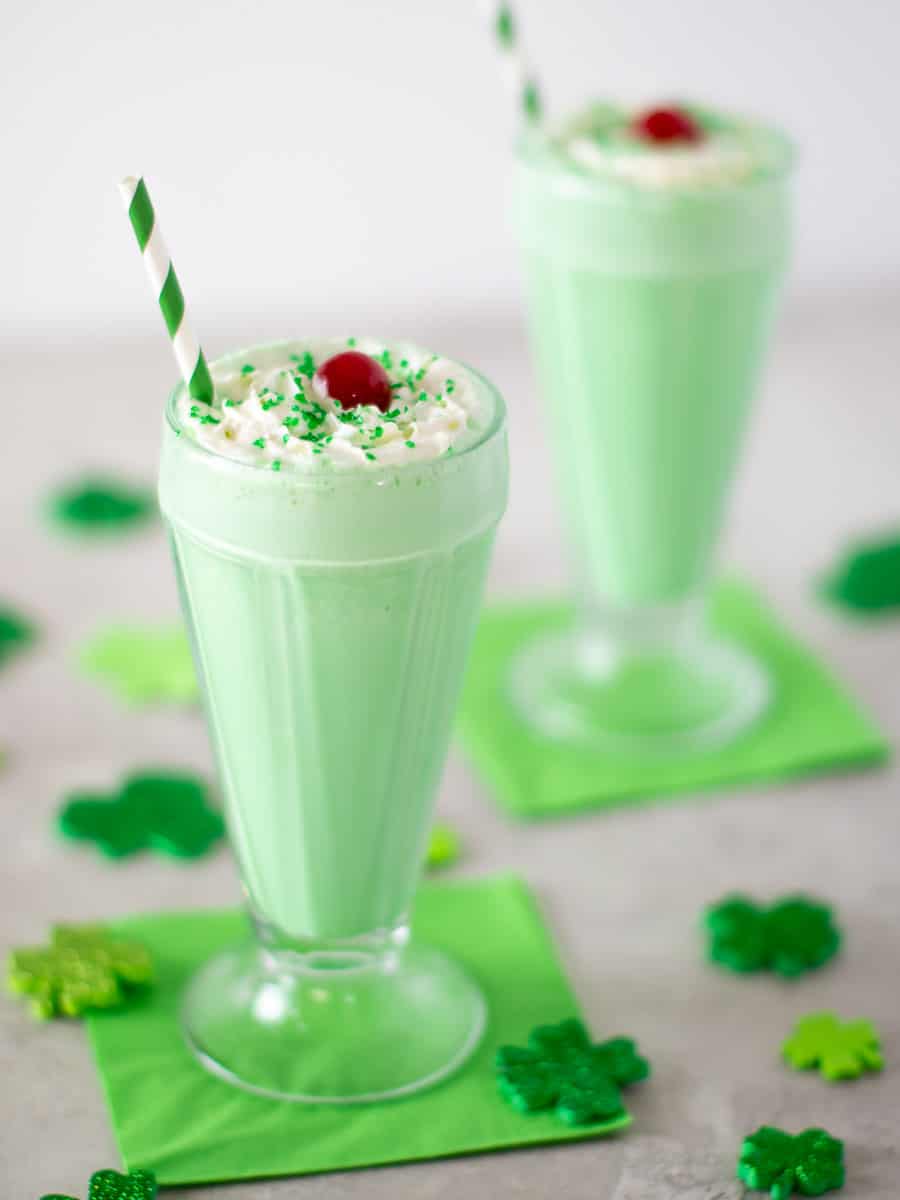 Angled picture of 2 glasses of mint milkshakes.