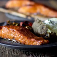 A plate of grilled salmon and a baked potato.