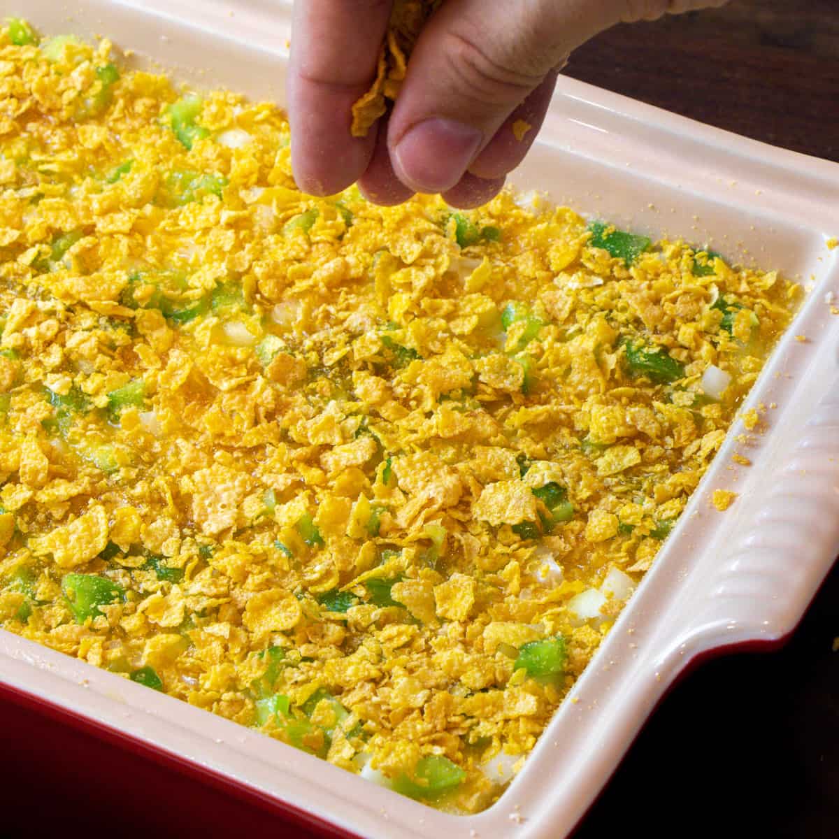 Sprinkling cereal on top of the casserole.
