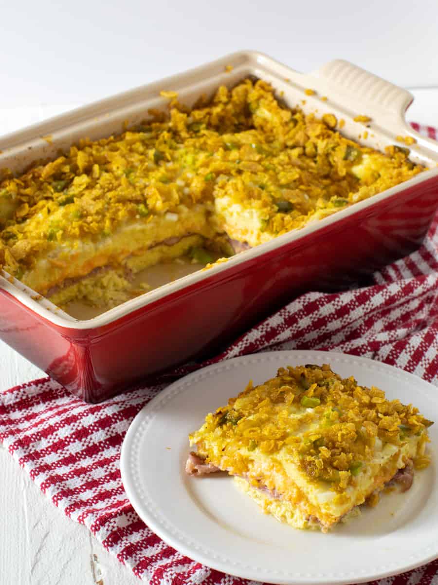 An overhead image of a casserole dish with a small plate of food in front.