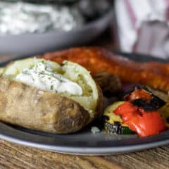 A dinner plate with salmon, grilled vegetables and potato..