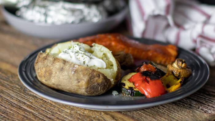 A dinner plate with salmon, grilled vegetables and potato..