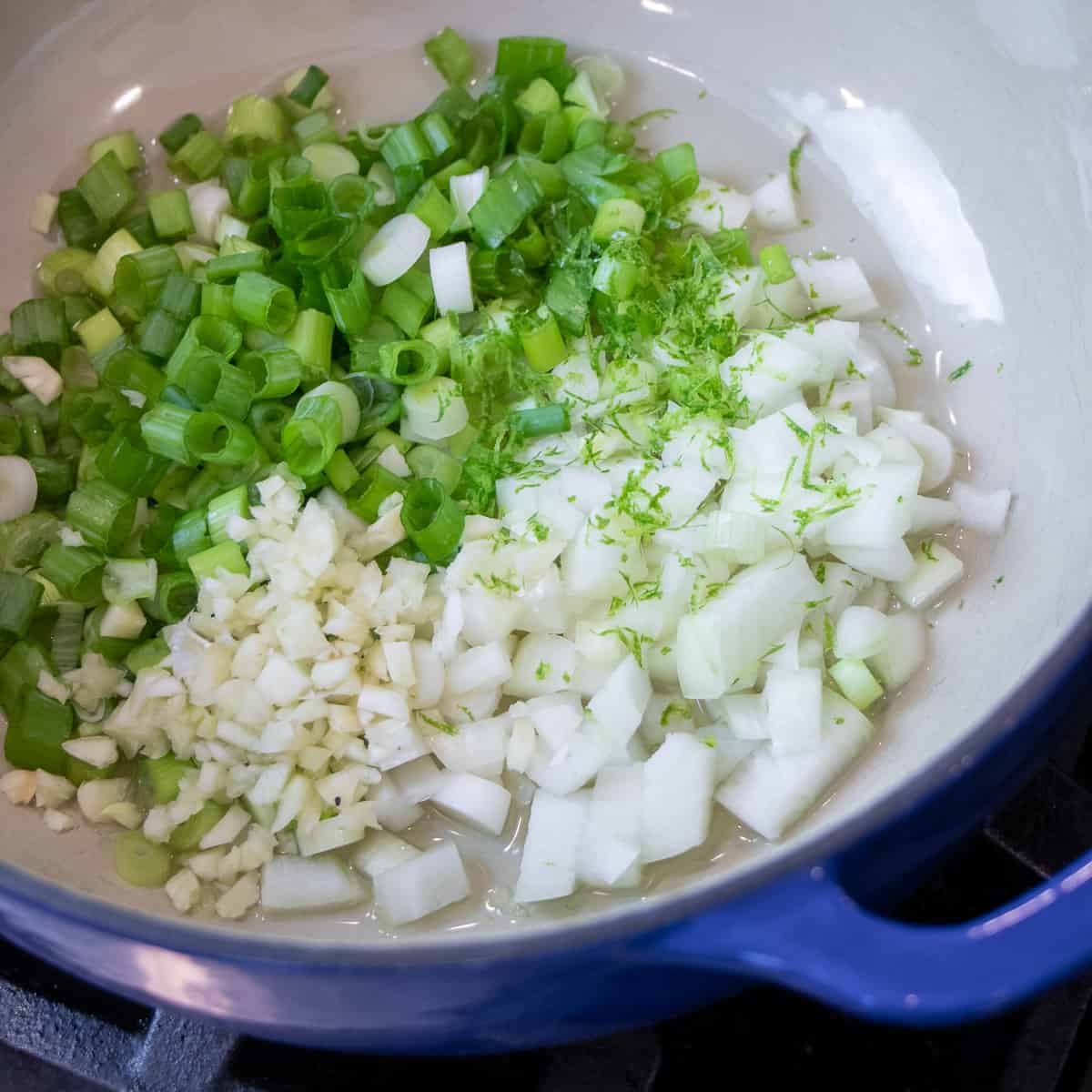 Diced onions and scallions in a dutch oven.