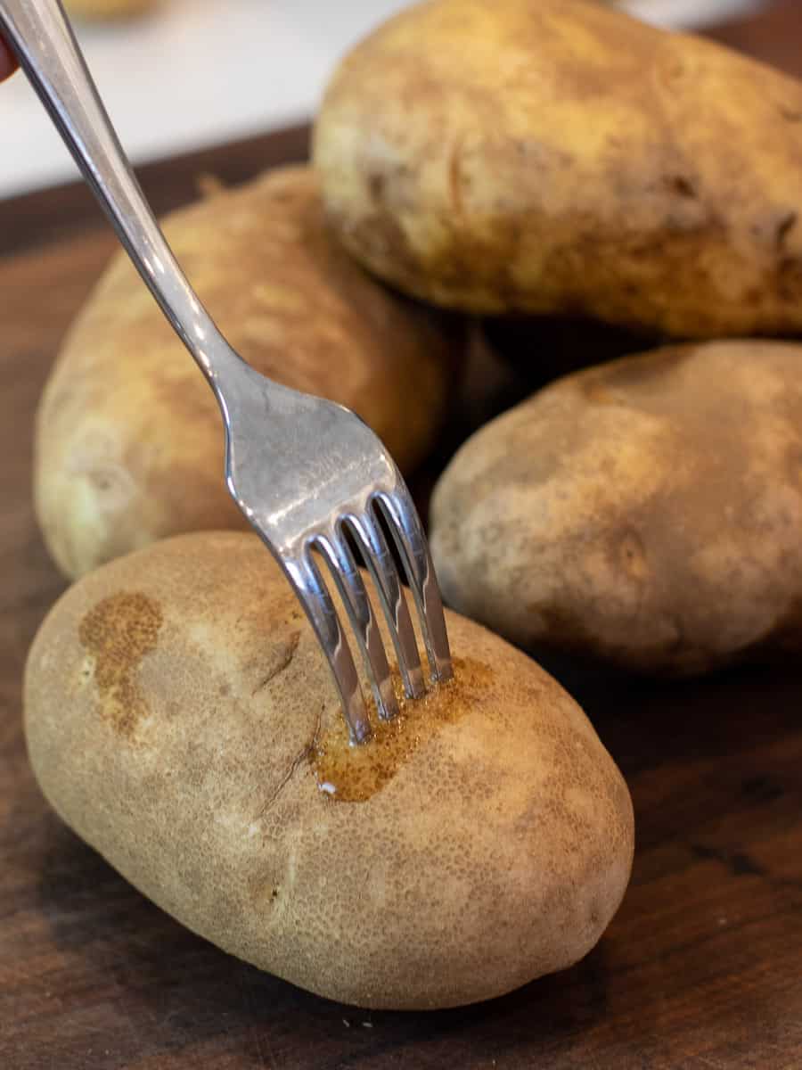 A fork pierced into a russet potato.