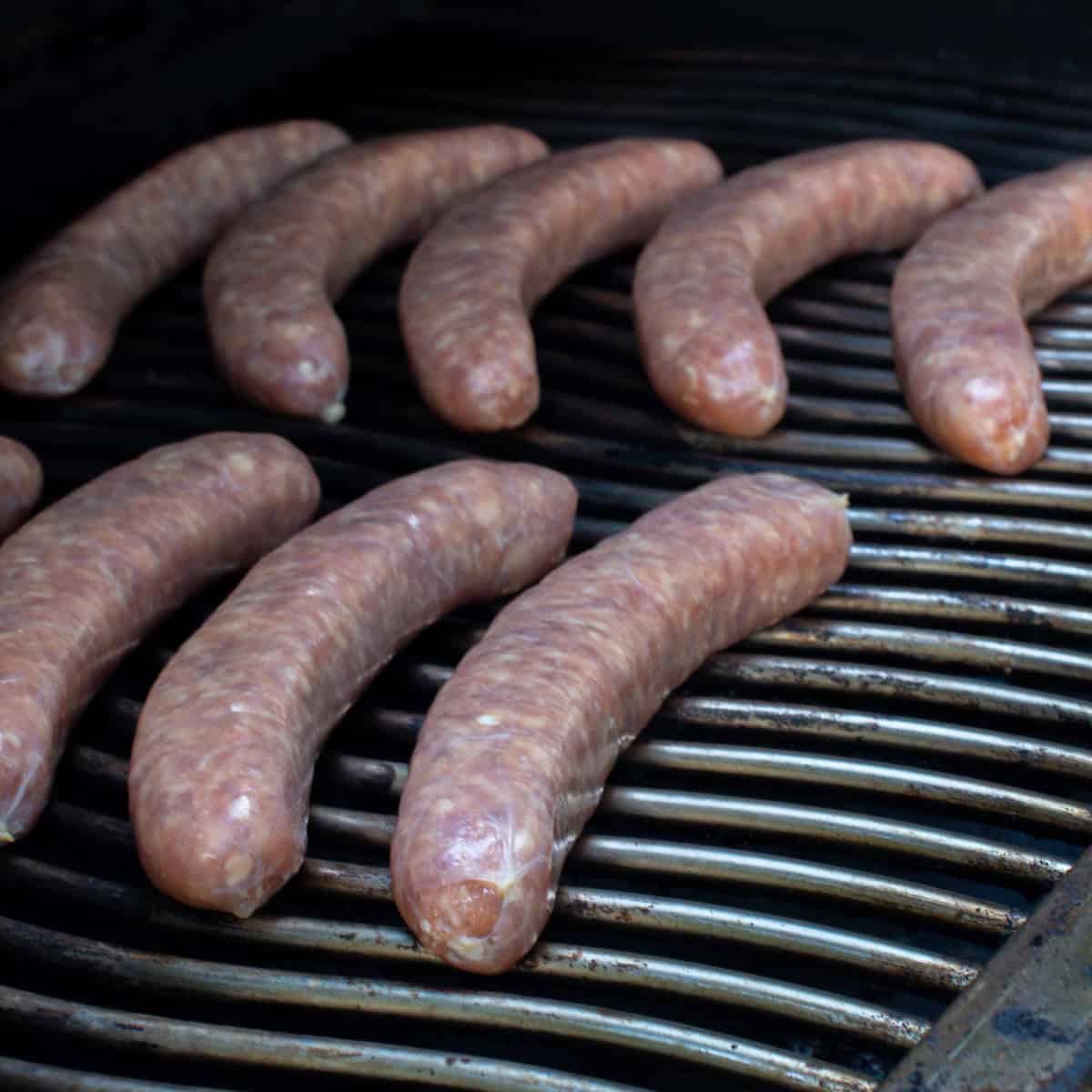 Raw sausages placed on a grill.