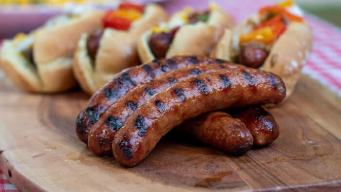 Grilled Italian Sausages with buns and toppings.