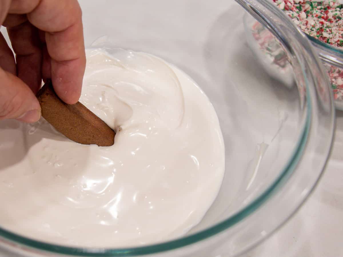 Dipping a chocolate cookie in melted white chocolate.