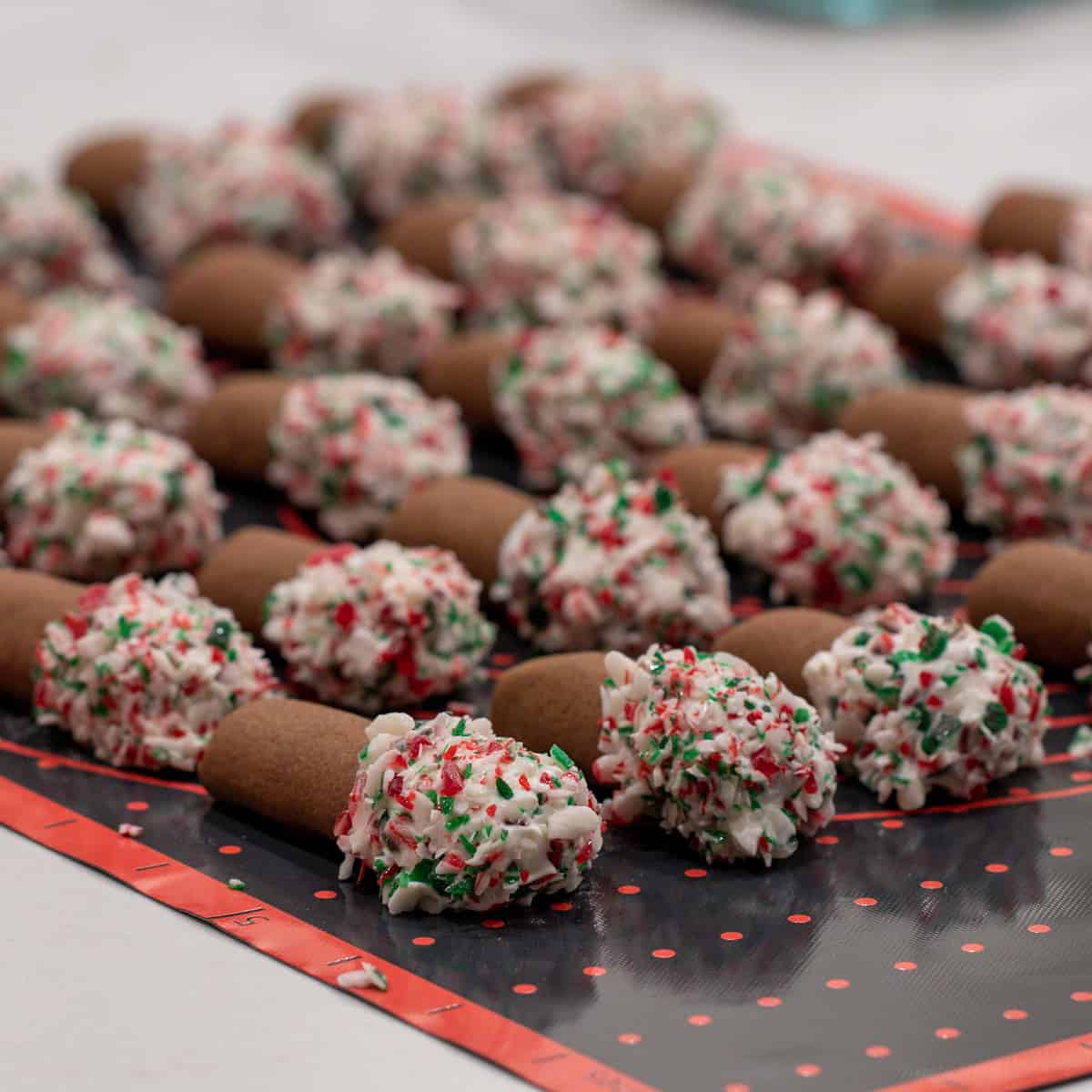 Dipped cookies resting on a silicone mat.