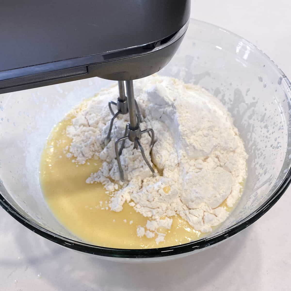 Beating the flour into the wet ingredients with an electric mixer.