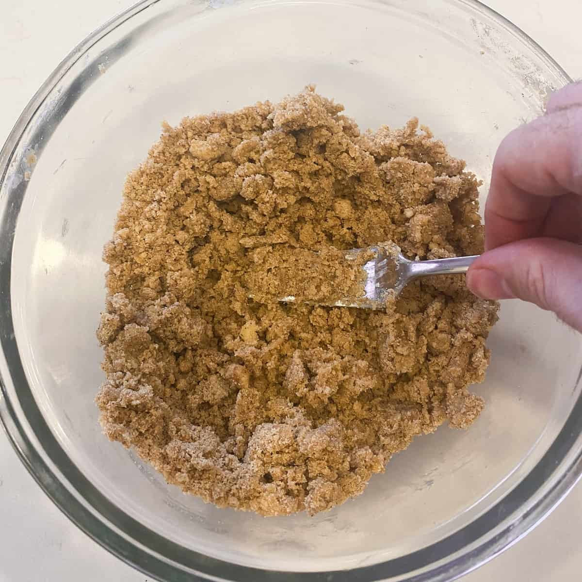 Using a fork to make the brown sugar crumble topping.