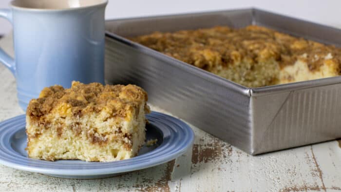 A small plate with a slice of fresh baked cake.