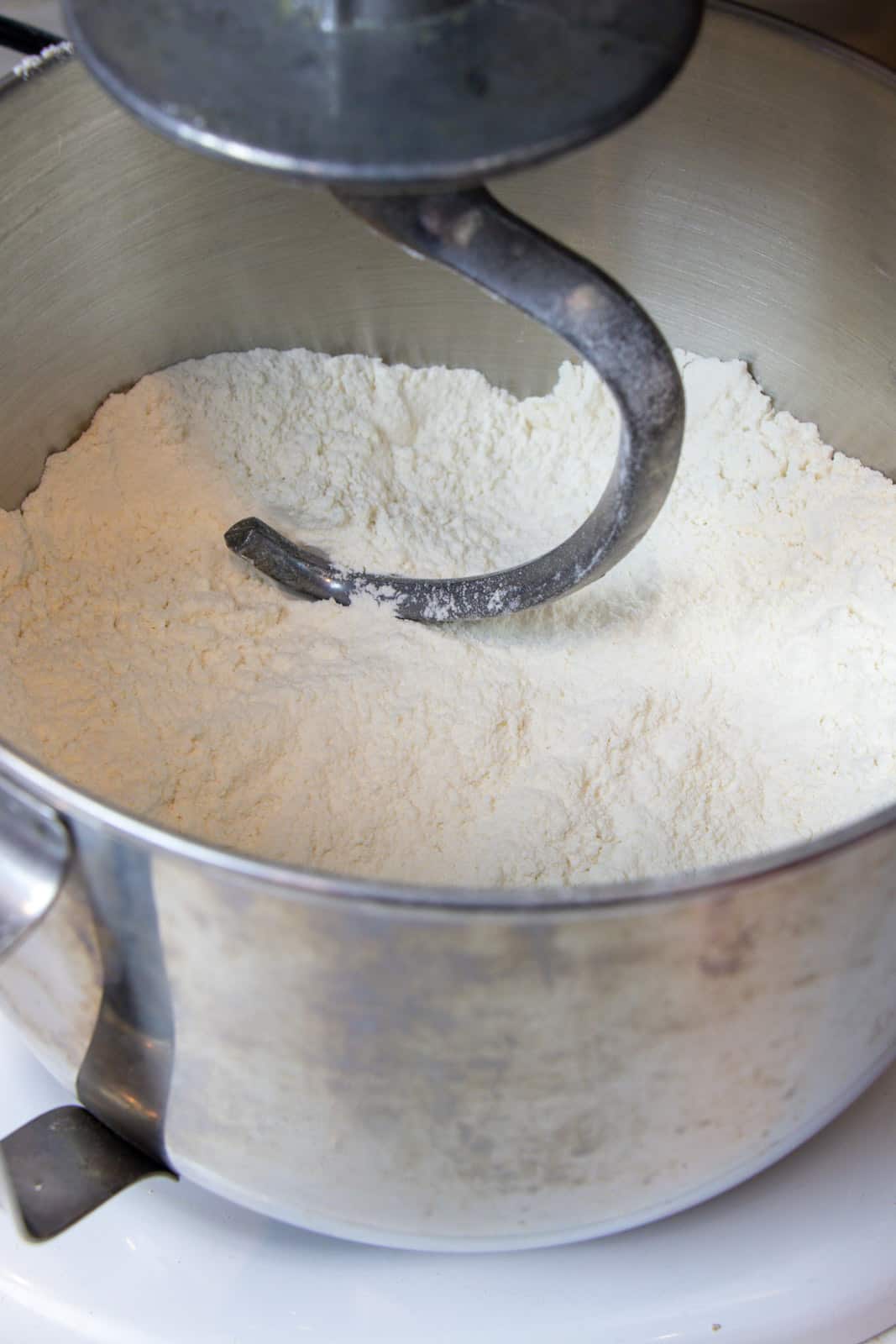 An electric mixing bowl filled with flour.