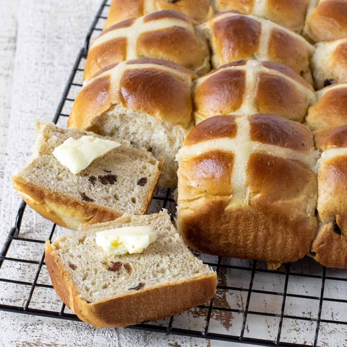 Sliced hot cross bun with butter.