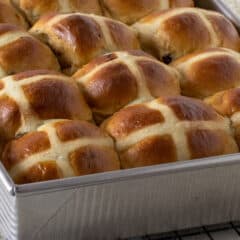 A rectangular baking dish full of fresh baked buns.