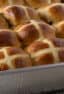 A rectangular baking dish full of fresh baked buns.