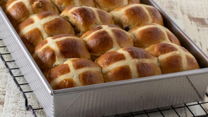 A rectangular baking dish full of fresh baked buns.