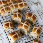 Fresh baked buns on a wire cooling rack.