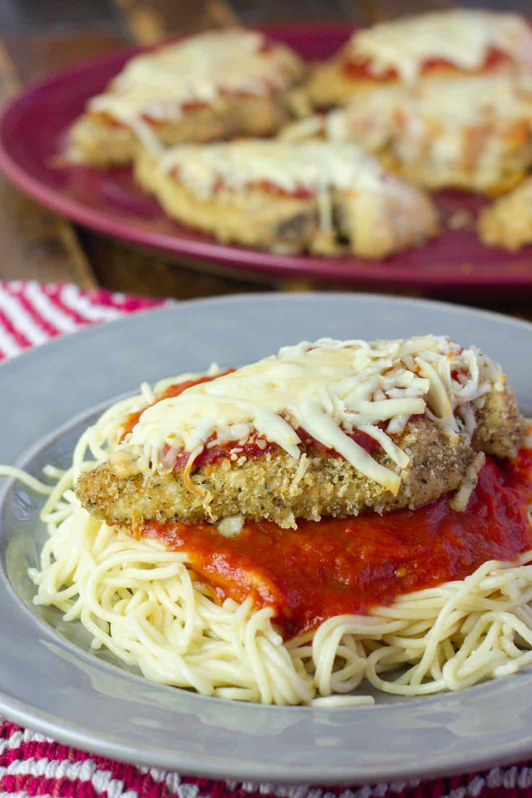 Baked chicken breast on a bed of pasta with sauce.