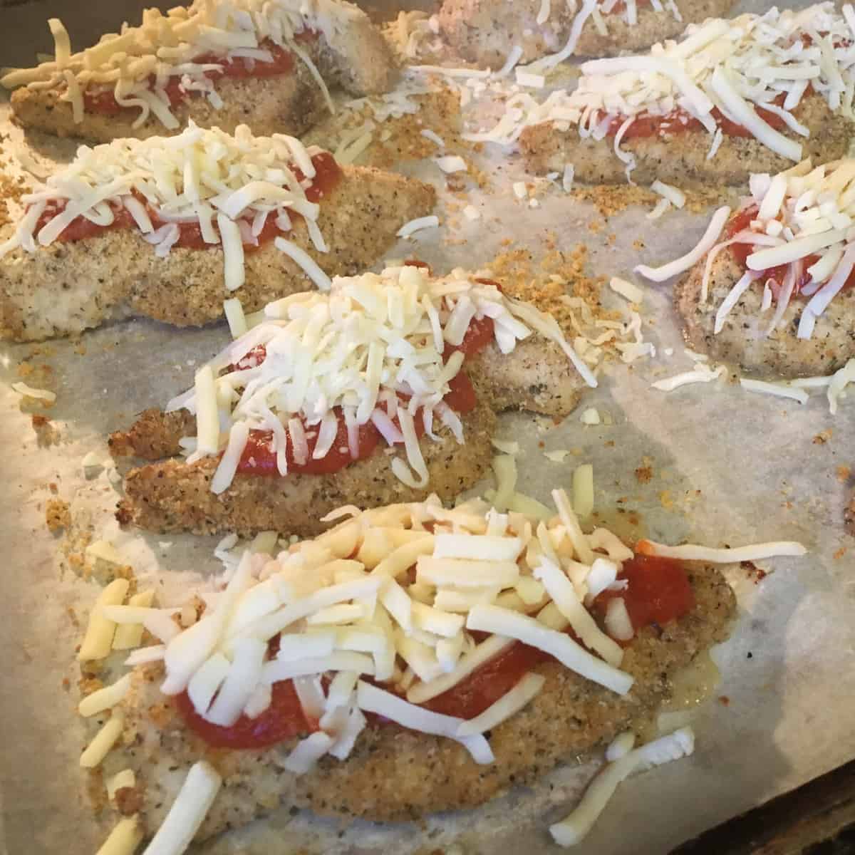 Grated mozzarella cheese and sauce topped on the chicken.